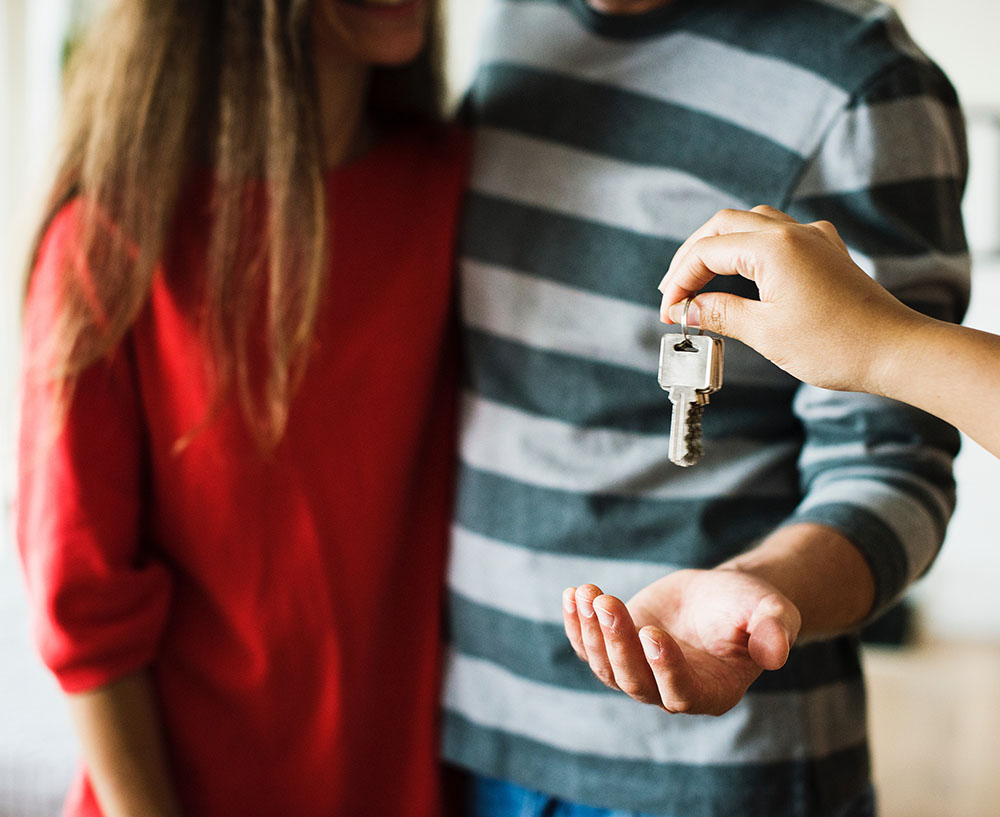 A yong couple receiving a set of house keys